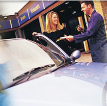 mechanic showing repaired car to customer